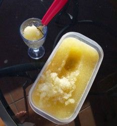 an ice cream dish with a red spoon next to it on a glass table top