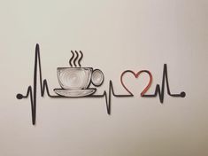 a cup of coffee with a heart on it next to a stethoscope