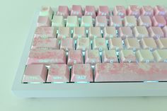 a pink and white computer keyboard sitting on top of a table