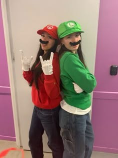 two people with fake mustaches on their mouths posing for a photo in front of a purple door