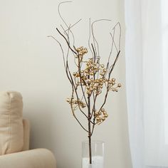 a vase filled with flowers sitting on top of a table next to a chair and window