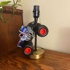 a toy truck on top of a wooden table next to a plant and remote control