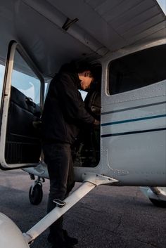 the man is getting out of the small plane