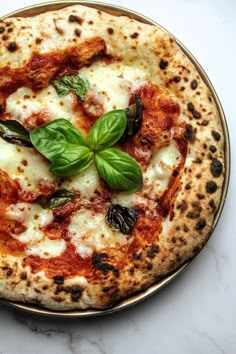 a small pizza with basil leaves on top