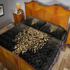 a bed with a black and gold comforter on top of it next to two nightstands