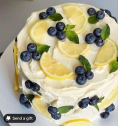 a white cake with lemons and blueberries on it