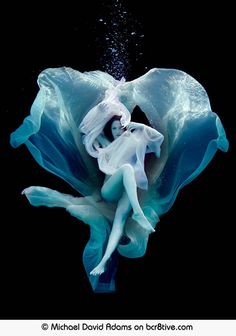 a woman in white dress floating under water