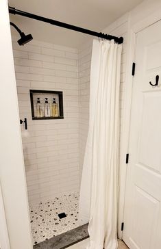 a bathroom with white tile and black fixtures