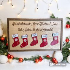 a wooden sign with christmas stockings hanging from it's sides