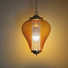 a yellow light hanging from a ceiling fixture