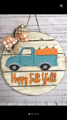 a sign that says happy fall y'all with a blue truck and pumpkins