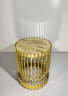 a round wooden table with metal bars on the top and bottom, against a white background