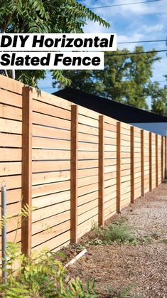 a long wooden fence next to a dirt road