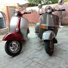 two scooters are parked next to each other