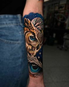 an owl with blue eyes and feathers on his arm is shown in this tattoo design