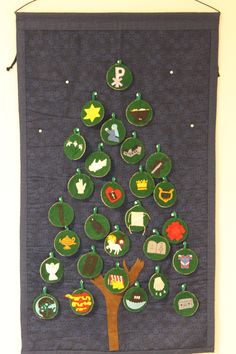 a christmas tree made out of felt and buttons on a wall hanging from a hook