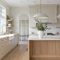 a large kitchen with white cabinets and wooden counter tops, along with an island in the middle