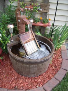 a wooden barrel filled with water next to a brick walkway and flower potted planter