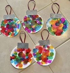 four paper plate ornaments with glitter on them