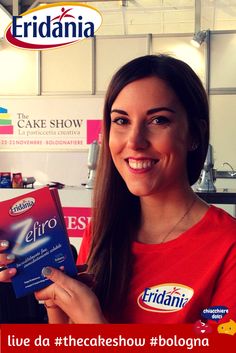 a woman holding up a book in front of her face and smiling at the camera