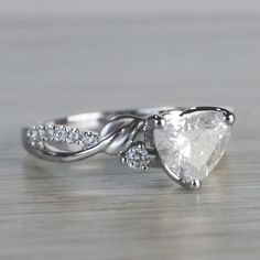 an engagement ring with a pear shaped diamond in the center and two diamonds on each side