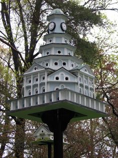 a bird house with two clocks on the top