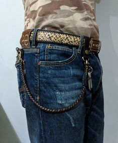 a person wearing jeans and a camo t - shirt with a belt on their back