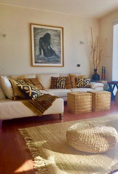 a living room filled with lots of furniture next to a large painting on the wall