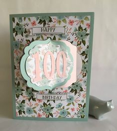 a handmade birthday card with the words happy 100th on it and flowers in front