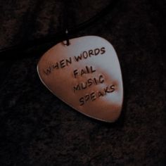 a guitar pick that says when words fail music speaks