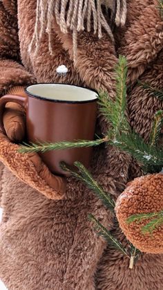 a teddy bear holding a coffee cup in his hands