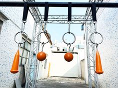 an outdoor area with several orange objects hanging from the ceiling