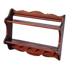 a wooden shelf with three hooks on it