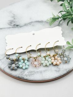 six pairs of earrings on top of a marble table