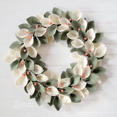 a wreath with white flowers and green leaves