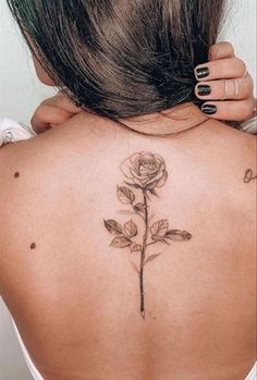 a woman with a rose tattoo on her back