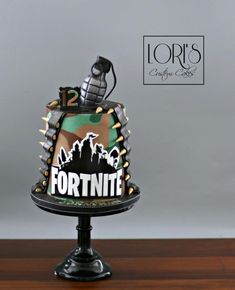 a cake that is sitting on top of a wooden table with the words fortnite printed on it