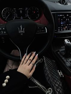 a woman is sitting in the driver's seat of a car with her hands on the steering wheel