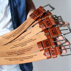 four leather guitar straps with words engraved on them