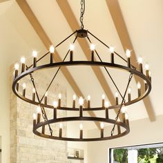 a large chandelier hanging from the ceiling in a room with exposed wood beams