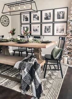 a dining room table with pictures on the wall above it and christmas decorations hanging from the ceiling