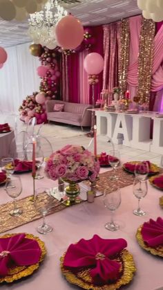 a table set up with pink and gold decorations