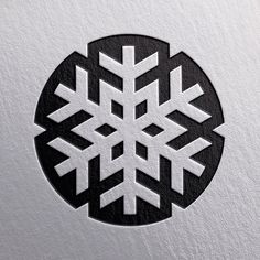 a black and white snowflake is on the side of a piece of paper