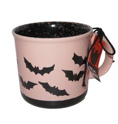 a pink and black mug with bats on it