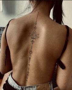 the back of a woman's body with tattoos on her upper and lower back