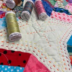 several spools of thread sitting on top of a quilt