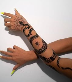 a woman's arm with tattoos on it and her hand in the shape of a sun