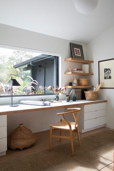 a chair sitting in front of a window next to a desk