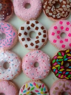 a box filled with lots of different flavored donuts covered in frosting and sprinkles