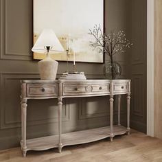 an elegant console table with two drawers and a lamp